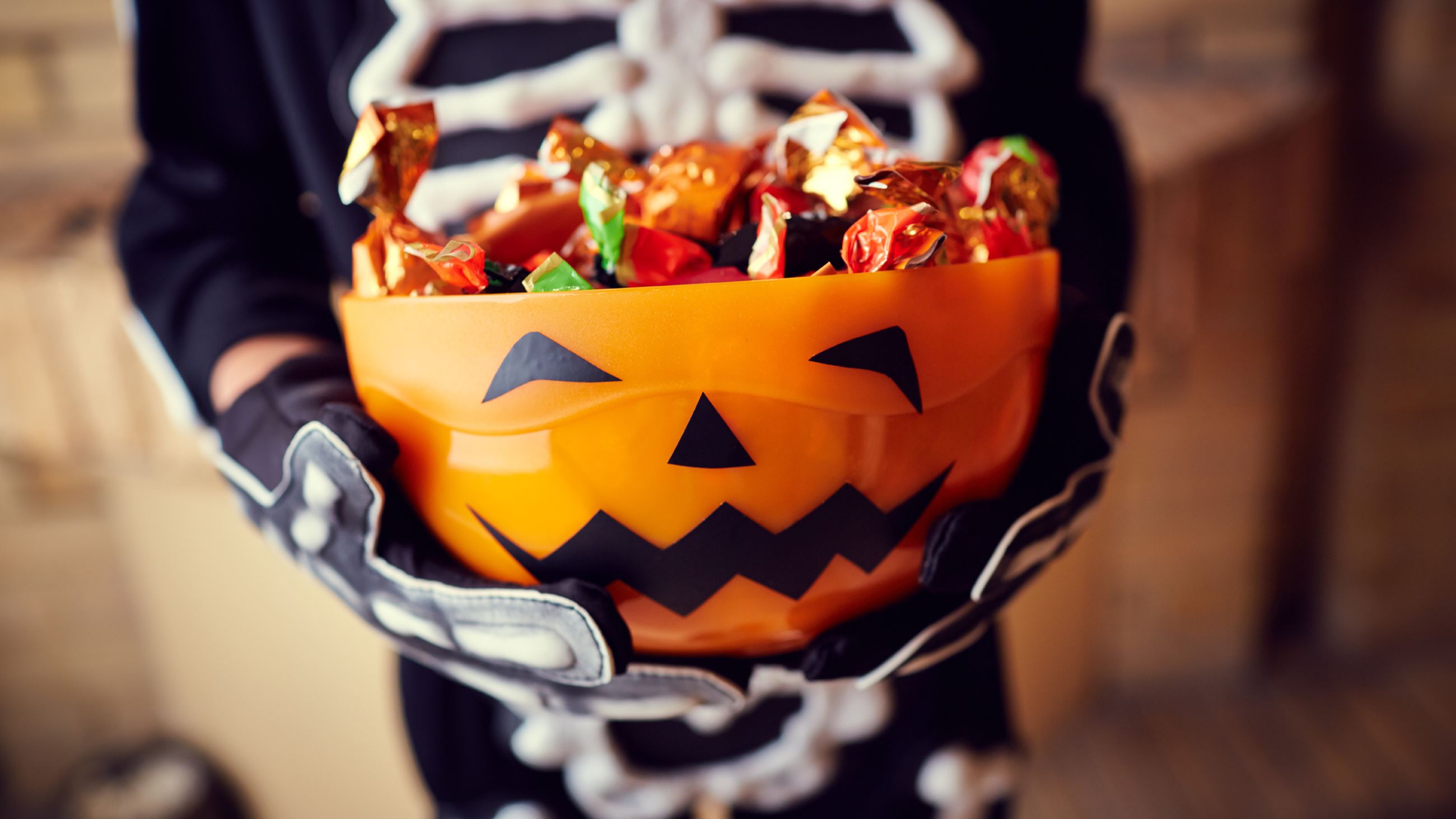 Child holding basket of candy on Halloween.