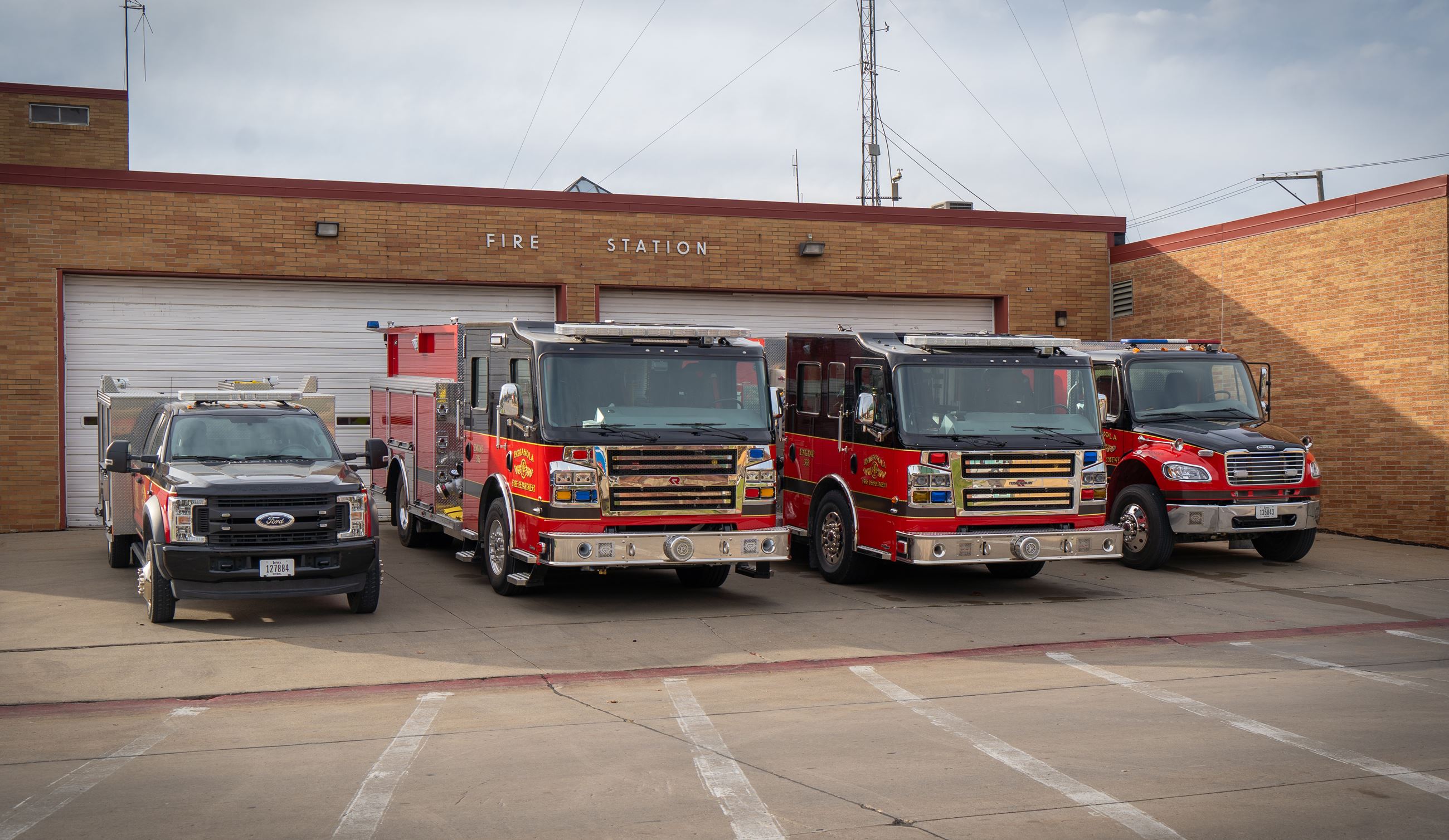 Four Indianola Fire Department apparatus parked outside the fire station.