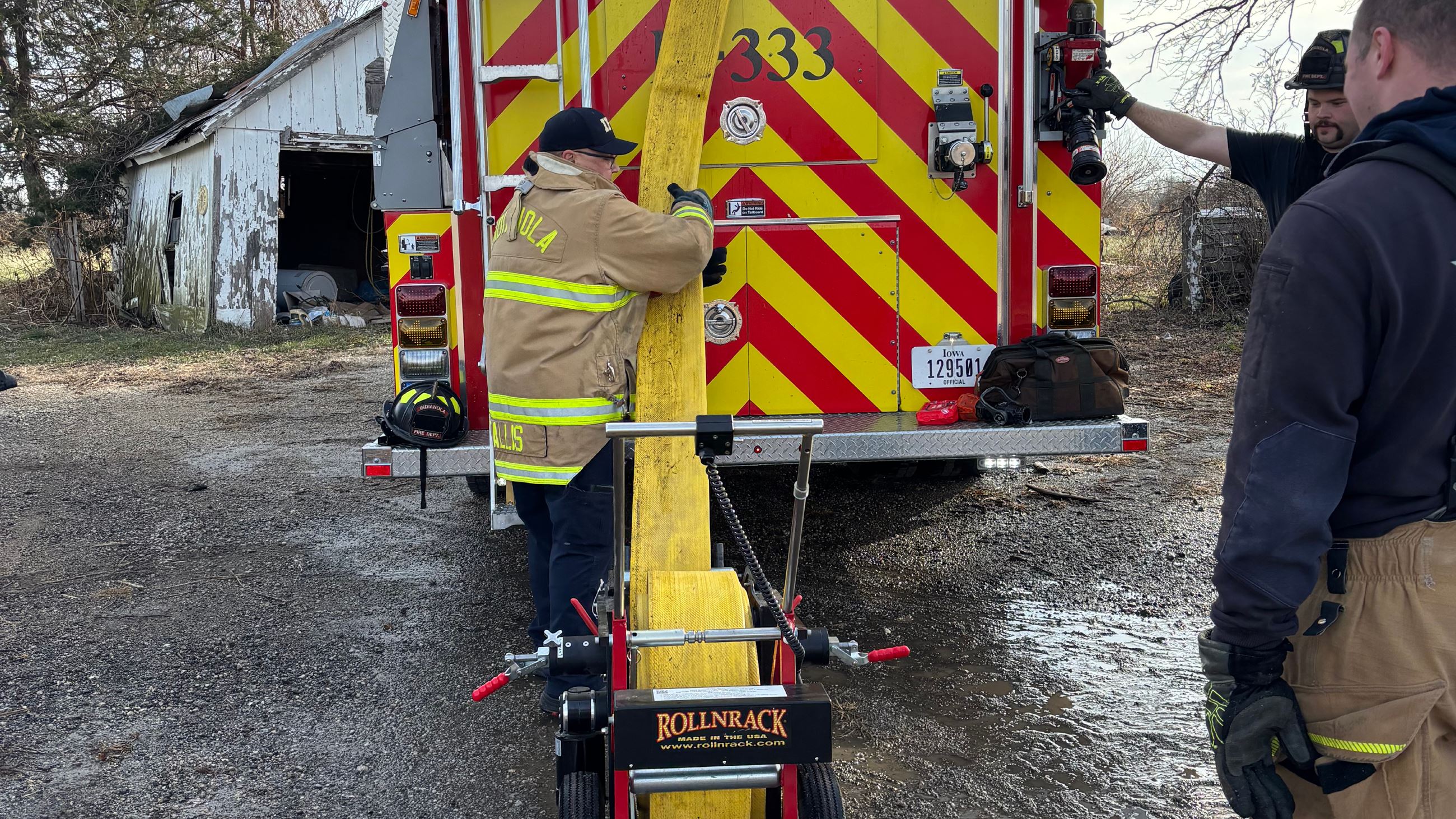 Indianola firefighters using the ROLLNRACK Power Roll near a fire truck.