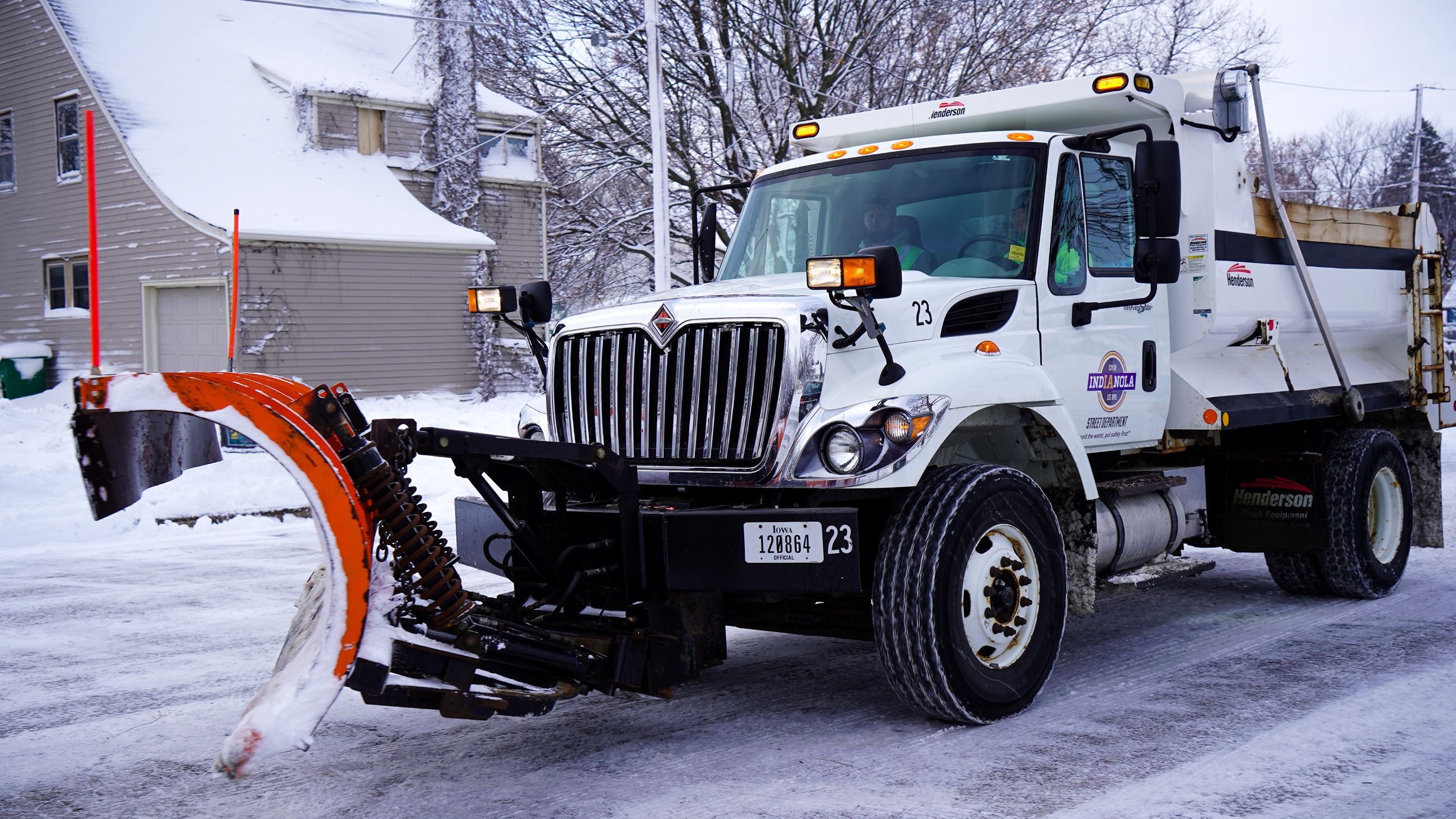 Snow plow clearing a street in Indianola, Iowa during a winter storm.