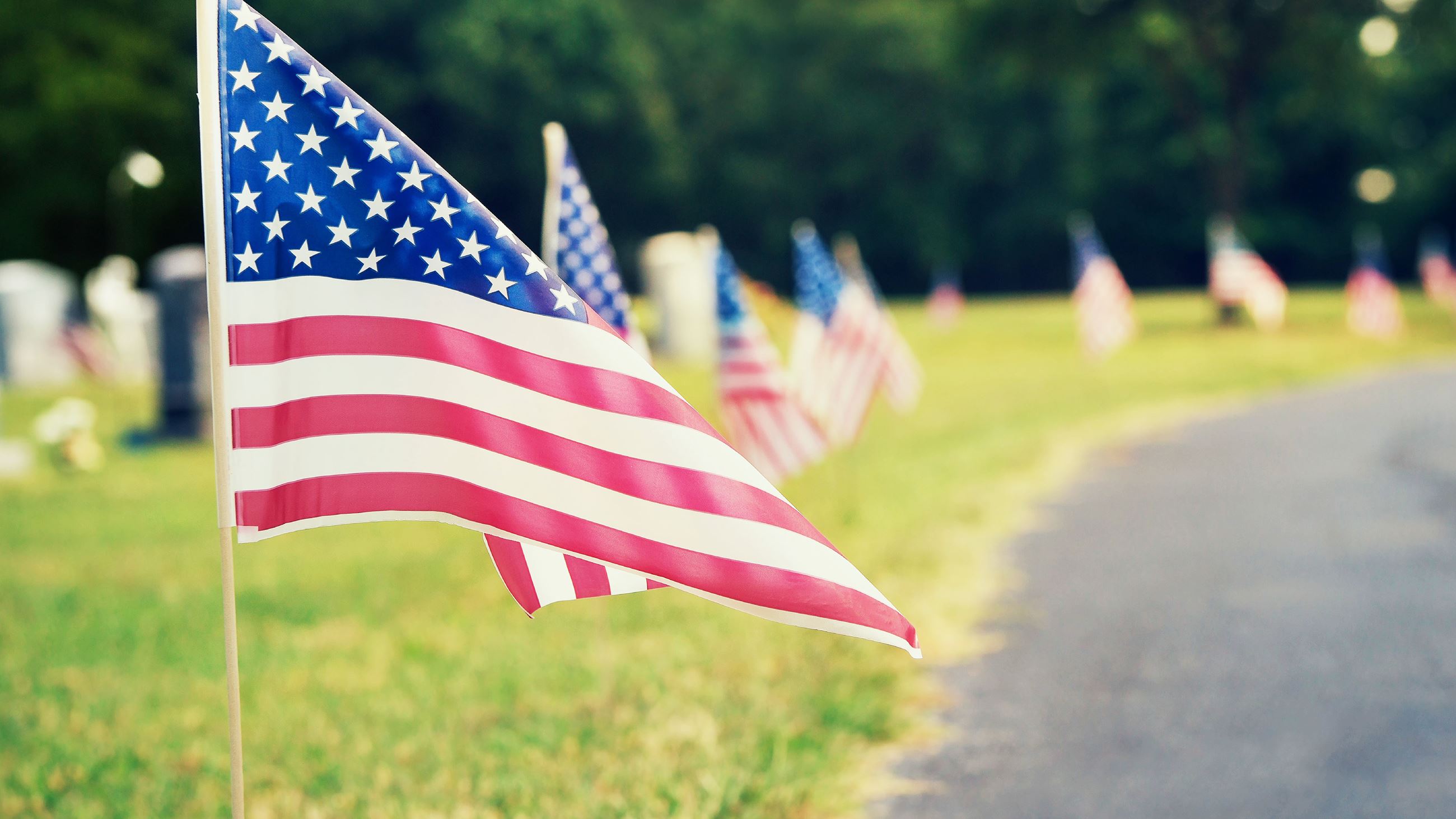 A U.S. flag blows in the wind at a cemetery.
