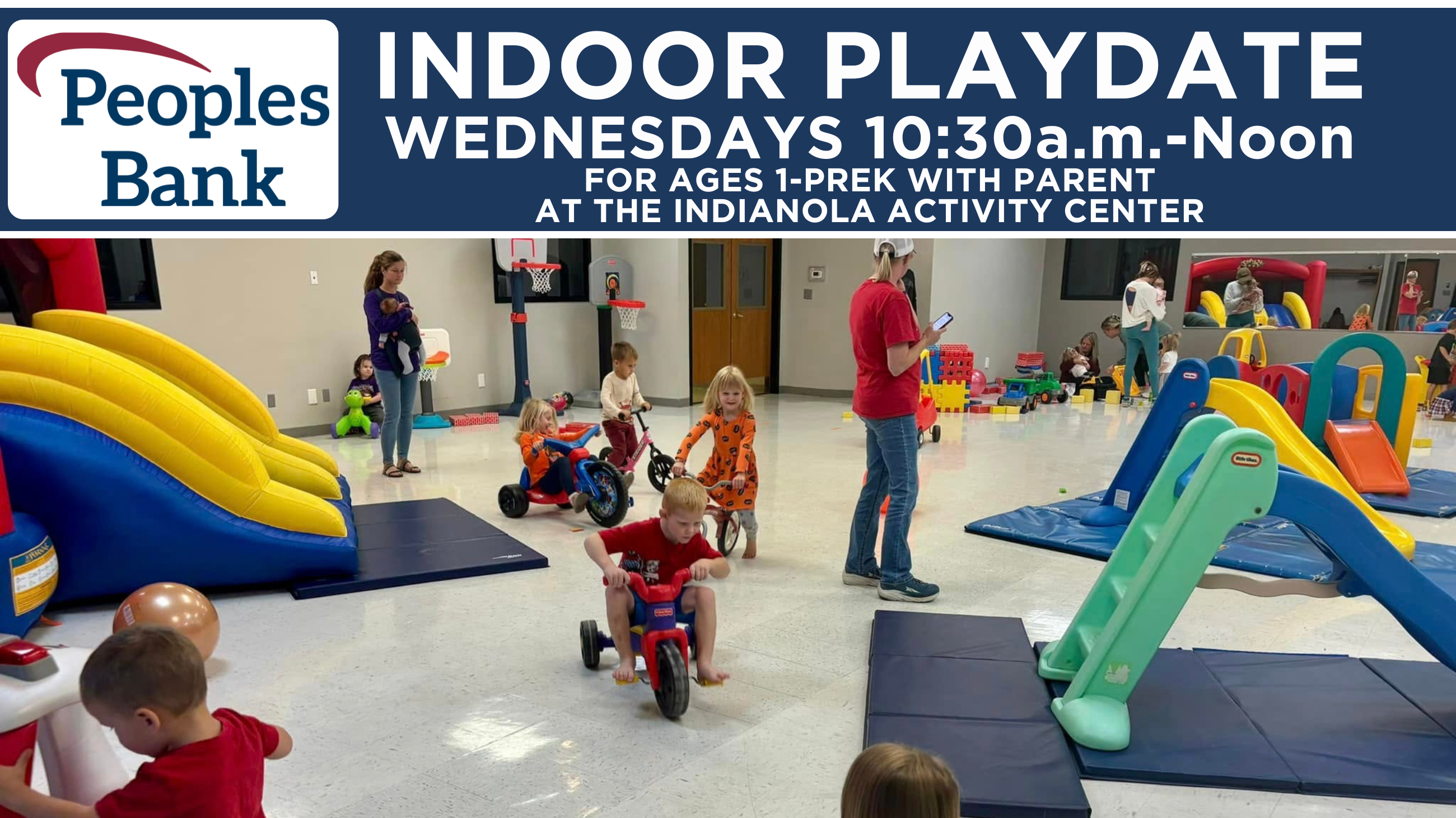Children playing indoors on riding toys and a bounce house