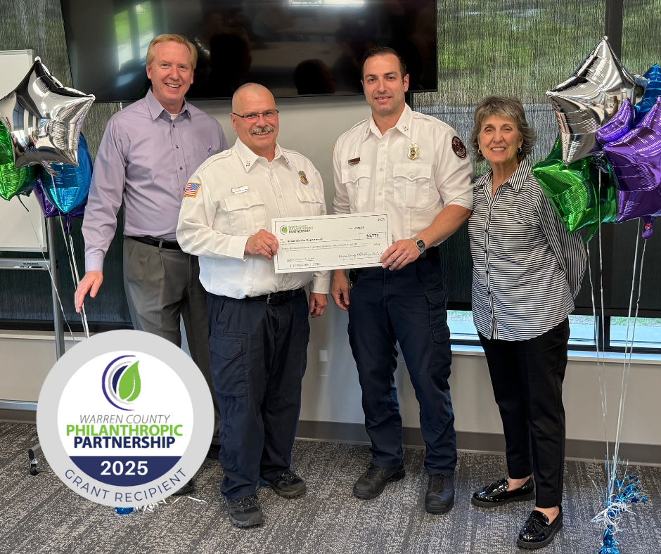 A group of people standing and holding a check.