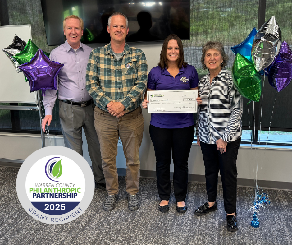 A group of people standing and holding a check.