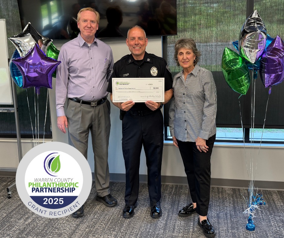 A group of people standing and holding a check.