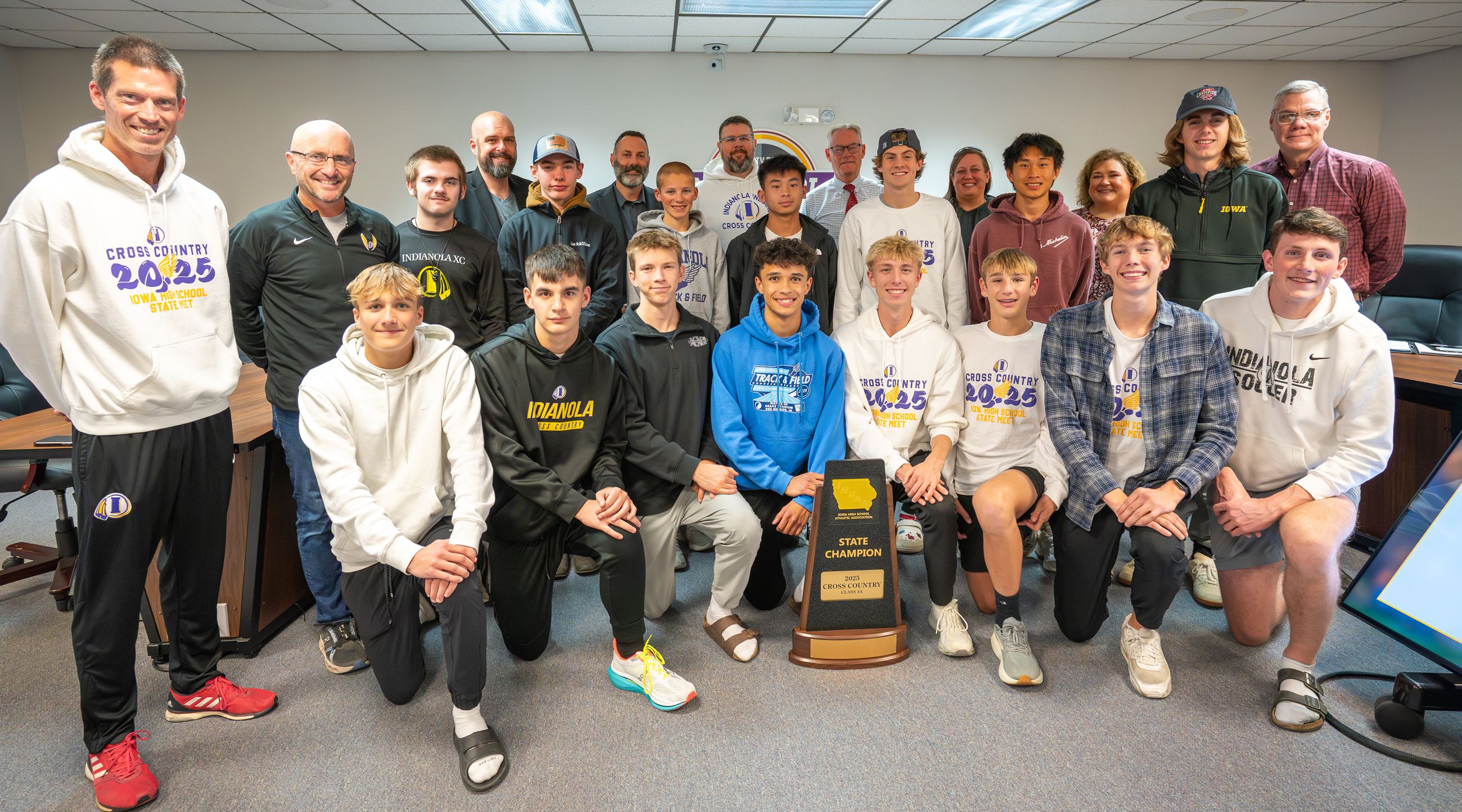 A group of people pose for a photo with a trophy.