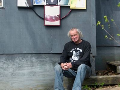 Man sitting outdoors next to wall art